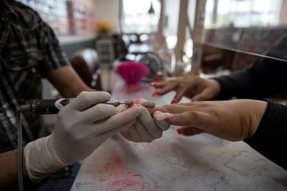 A person using a nail file to remove a nail polish